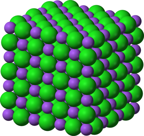 A cube made of tightly packed purple and green spheres. (chemical image of sodium chloride)