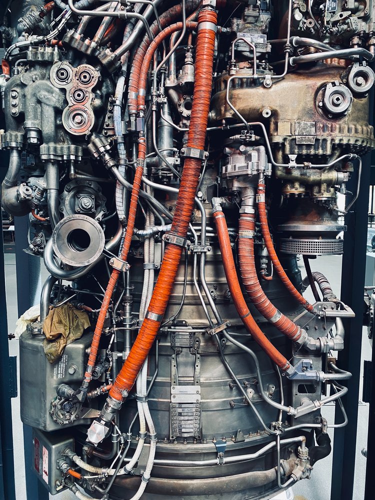 A complex engine with tubes and cables running over it