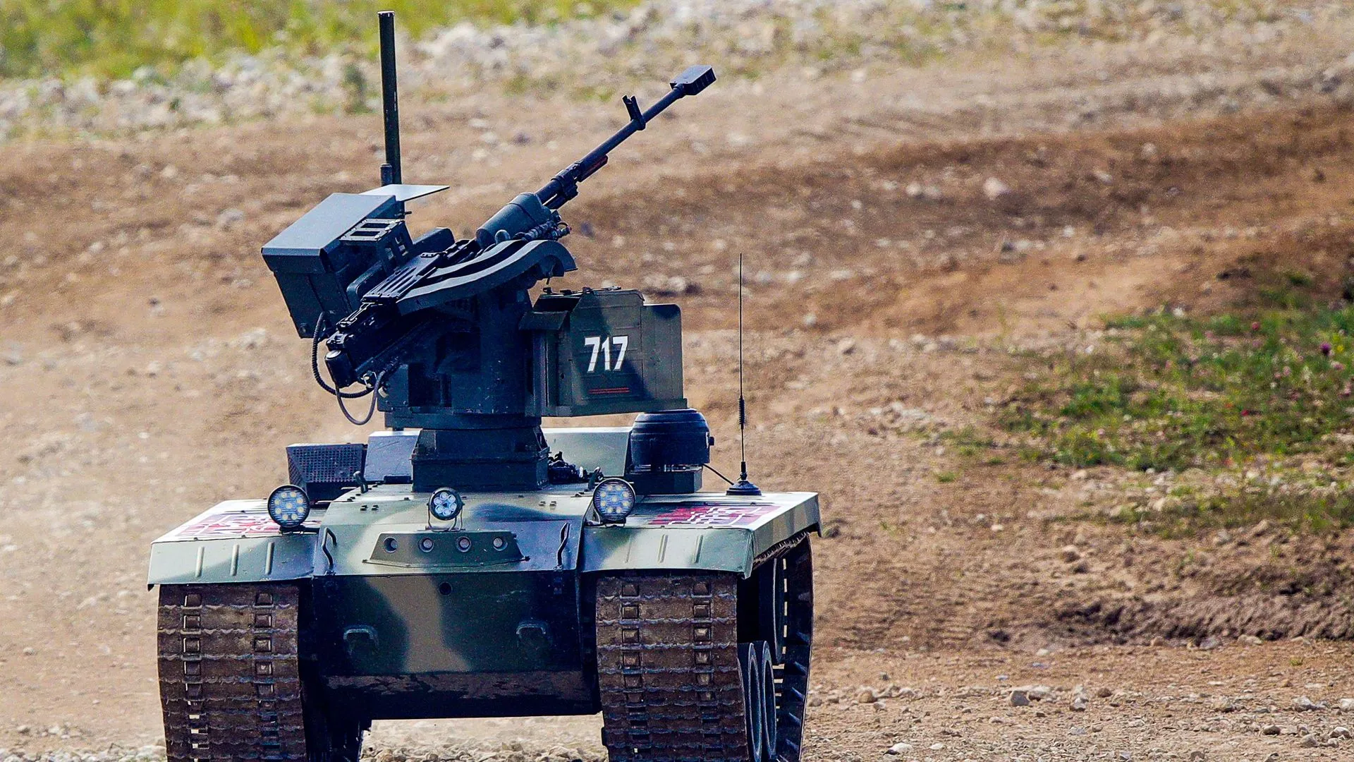 A small robotic tank, painted in military camouflage, with a machine gun mounted on it.