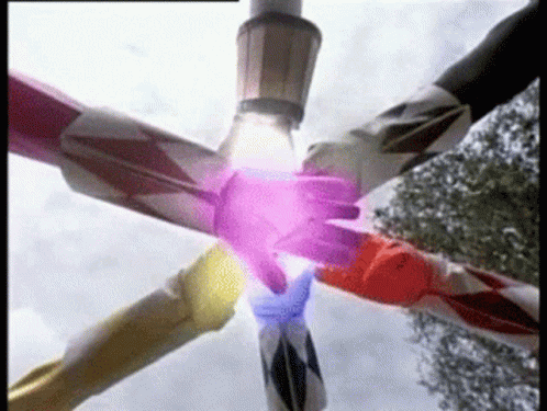 Animation of six characters in different brightly colored full-body outfits placing their hands in the center of a circle (power rangers). A spark of energy seems to shoot from their bodies to the point where their hands meet