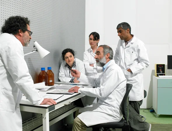 Photo of two scientists arguing, with three other scientists watching.
